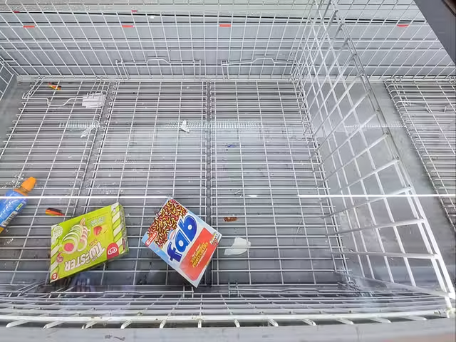 Làn sóng nhiệt khiến các kệ hàng siêu thị trống rỗng khi người mua sắm đua nhau mua nước và kem  - Ảnh 1.