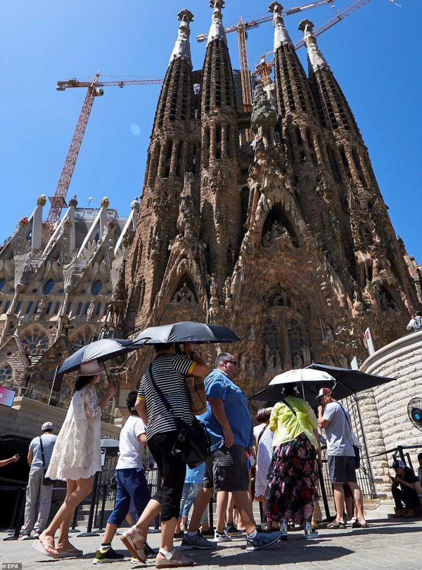 KhÃ¡ch du lá»ch dÃ¹ng Ã´ che náº¯ng khi Äáº¿n thÄm thÃ¡nh ÄÆ°á»ng Sacred Family á» Barcelona, TÃ¢y Ban Nha.