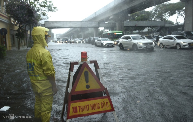 Đường phố Hà Nội ngập lụt khiến người dân đi lại khó khăn. Ảnh: VNExpress