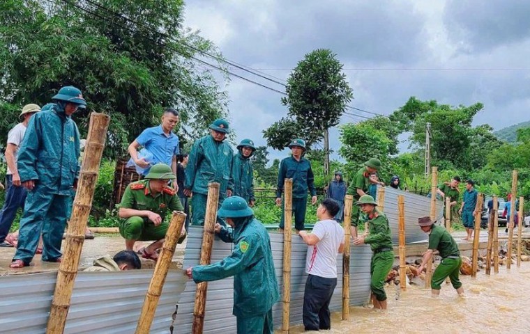 Công an xã Hùng Chân, tỉnh Nghệ An phối hợp chính quyền địa phương và nhân dân khắc phục tuyến đường qua bản Luông bị xói lở do mưa bão gây ra. Ảnh: Đình Phượng.